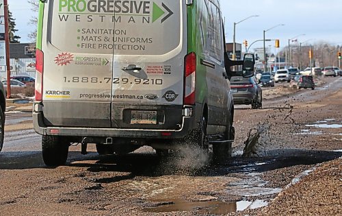 Unable to avoid them, a vehicle drives through a line of water-filled potholes on Richmond Avenue on Tuesday afternoon. (Matt Goerzen/The Brandon Sun)