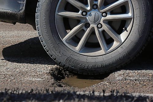 A tire on a northbound vehicle nearly hits the centre of a pothole on 18th Street near Richmond Avenue on Tuesday afternoon. (Matt Goerzen/The Brandon Sun)