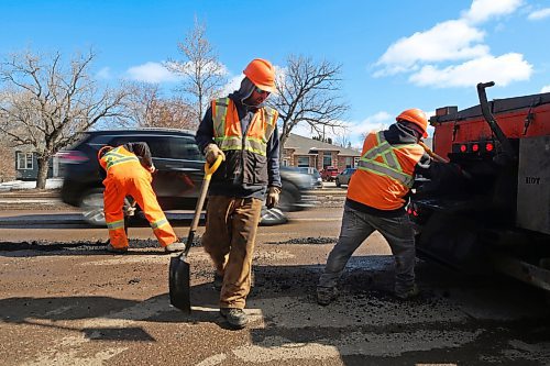 Traffic passes by a Manitoba highways crew while they patch hundreds of potholes along the southbound lanes of 18th Street on Tuesday afternoon. (Matt Goerzen/The Brandon Sun)