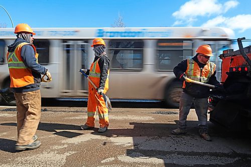A Brandon Transit bus passes by a Manitoba highways crew while they patch hundreds of potholes along the southbound lanes of 18th Street on Tuesday afternoon. (Matt Goerzen/The Brandon Sun)