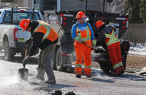 Workers with the Manitoba Transportation and Infrastructure department patch a series of potholes along First Street on Tuesday afternoon. (Matt Goerzen/The Brandon Sun)
