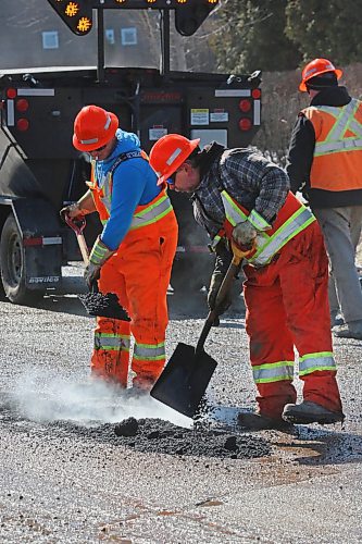 Workers with the Manitoba Transportation and Infrastructure department patch a series of potholes along First Street on Tuesday afternoon. (Matt Goerzen/The Brandon Sun)