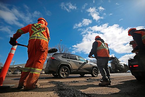 Traffic passes by a work crew with Manitoba Transportation and Infrastructure while they patch hundreds of potholes along the southbound lanes of 18th Street on Tuesday afternoon. (Matt Goerzen/The Brandon Sun)