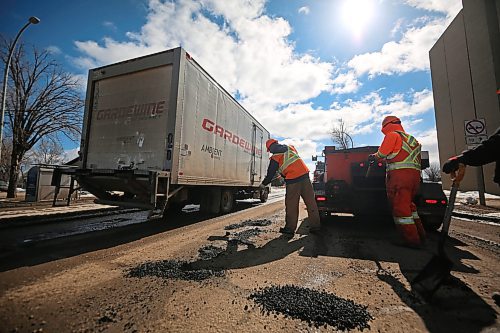 A truck passes a pothole patching crew from Manitoba Transportation and Infrastructure on Tuesday afternoon on the southbound lanes of 18th Street near Brandon University. (Matt Goerzen/The Brandon Sun)