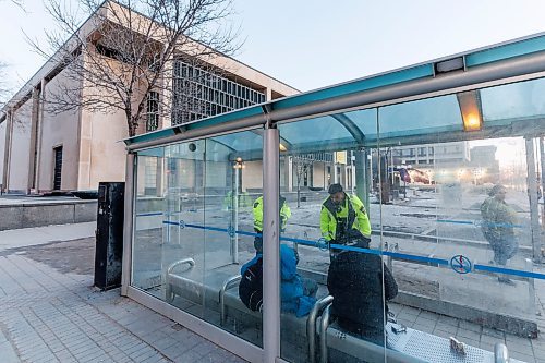 MIKE DEAL / WINNIPEG FREE PRESS
Community Safety Officers check the wellbeing of a person in the bus stop outside City Hall on Main Street early Friday morning.
See Malak Abas story
240322 - Friday, March 22, 2024.