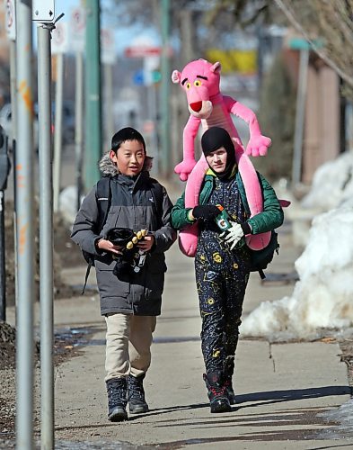 A Pink Panther stuffie gets a lift down 10th Street toward Victoria Avenue from Titus, right, and his friend Tony on a bright and sunny Friday afternoon for the start of the spring break holiday. (Matt Goerzen/The Brandon Sun)