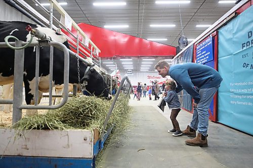 Winnipeg resident Brenna Scarff and his three-year-old son Charlie look at the dairy cows in the Royal Farm Yard on Monday afternoon. (Matt Goerzen/The Brandon Sun)
