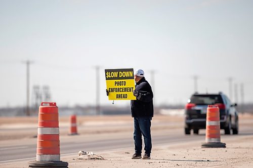 BROOK JONES / FREE PRESS
Todd Dube of Wise Up Winnipeg holds a sign while looking back at a passing vehicle. Dube was alerting drivers to slow down because the Winnipeg Police Service is using photo radar and enforcement equipment to monitor the speed of vehicles and photograph vehicles that are speeding in the construction zone for the St. Mary's Road interchange at the Perimeter Highway in Winnipeg, Man., Monday, March 25, 2024.