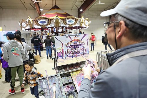 Well-known Brandon painter Weiming Zhao puts the final touches on a portrait of the merry-go-round in the Manitoba Room during the first day of the Royal Manitoba Winter Fair on Monday afternoon. (Matt Goerzen/The Brandon Sun)