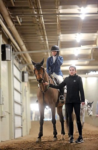 A horse and rider and a handler wait in the wings while another rider runs the Gamber's Choice show riding course at the Westoba Place Arena on Monday night, during the opening day of the Royal Manitoba Winter Fair. (Matt Goerzen/The Brandon Sun)