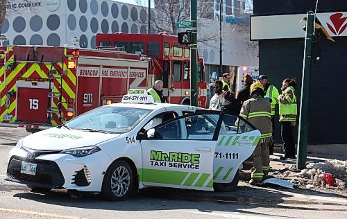 A fireman leads a person away to an ambulance from a taxi that was involved in a two-vehicle collision with a Dodge Journey at the corner of Sixth Street and Princess Avenue on Wednesday afternoon. The collision drew several Brandon Police vehicles, as well as Brandon Fire and Emergency Services, including at least two ambulances. It's unknown if anyone was injured as a result of the collision. (Matt Goerzen/The Brandon Sun)