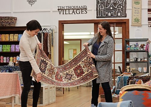 Julianna Murray (left), assistant manager at Ten Thousand Villages examines a hand made fair trade runner rug with Stephanie De la Luz, store manager in Brandon on Thursday, in preparation of the store's upcoming Fair Trade Rug Event happening April 4 - 22, 2024 in Brandon. (Michele McDougall/The Brandon Sun) 