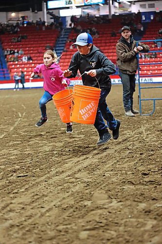 Lexi and Dawson Leader race for the finish line with their buckets during the Provincial Ex of Manitoba Youth Obstacle Course on Wednesday evening, during the Royal Manitoba Winter Fair. (Matt Goerzen/The Brandon Sun)