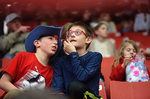 Two boys talk while sitting in the stands of Westoba Place Arena during the Wednesday evening show of the Royal Manitoba Winter Fair. (Matt Goerzen/The Brandon Sun)