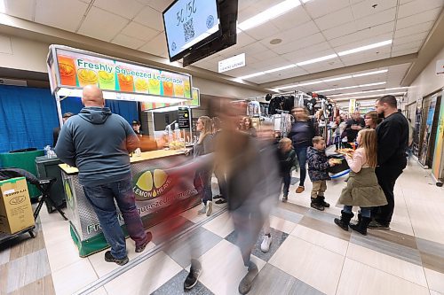 Fairgoers pass customers at a lemonade stand in the halls of the Keystone Centre on Thursday afternoon during the fourth day of the Royal Manitoba Winter Fair. (Matt Goerzen/The Brandon Sun)