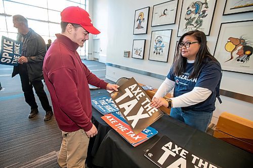 BROOK JONES / FREE PRESS
Keenan Mellum (left), 25, picks up an 'Axe the Tax' sign from Janice Wy, who is from Winnipeg North Conservative candidate Rachel Punzalan's team of supporters, during the Conservative Party of Canada Leader Pierre Poilievre's 'Spike the Hike - Axe the Tax' rally at the RBC Convention Centre in Winnipeg, Man., Thursday, March 28, 2024.