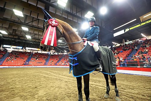 First place finishers in the Dog/Horse Relay, Piet Van Genugten and horse Kaiden GPH, pose with their winning ribbon in the Westoba Place Arena on Wednesday evening during the Royal Manitoba Winter Fair. (Matt Goerzen/The Brandon Sun)