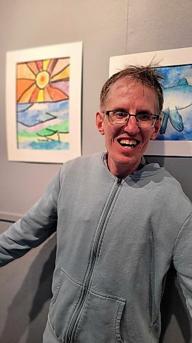 Neepawa artist Stan Szwagirczak stands in front of a picture of a sunset he created at ArtsForward in Neepawa on April 3. A luncheon and gala grand opening was held that day to raise money for an accessible playground. (Miranda Leybourne/The Brandon Sun)