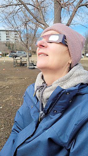 Louise Frances views April 8's solar eclipse through a pair of safety glasses in Neepawa. (Miranda Leybourne/The Brandon Sun)