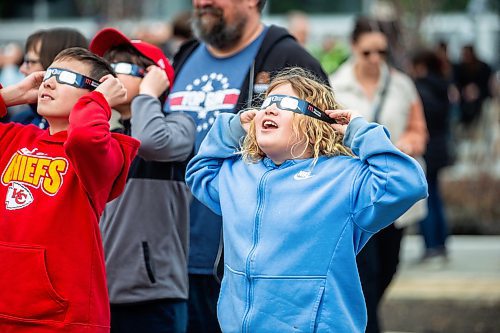 MIKAELA MACKENZIE / FREE PRESS
	
Kelsie Mulvey, eight, looks through her eclipse glasses at the solar eclipse viewing party at The Leaf in Assiniboine Park on Monday, April 8, 2024. 

For Nicole story.