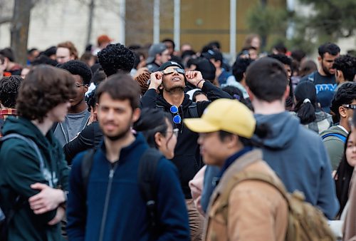 MIKE DEAL / FREE PRESS
Physics student, Nathaniel Casiano, one of hundreds of students that gathered on the Quad at the University of Manitoba to collect free viewing glasses and watch the partial solar eclipse during an overcast Monday afternoon.
240408 - Monday, April 08, 2024.