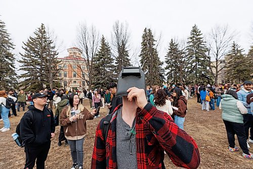 MIKE DEAL / FREE PRESS
Bryce Pantel a Mechanical Engineering student, wears a welding mask to view the partial eclipse at the UofM.
Students gather on the Quad at the University of Manitoba to collect free viewing glasses and watch the partial solar eclipse during an overcast Monday afternoon.
240408 - Monday, April 08, 2024.