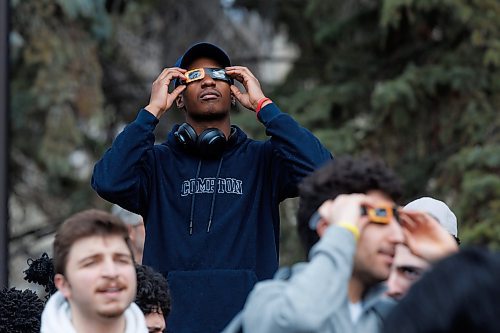 MIKE DEAL / FREE PRESS
Joshua Mudiwa, Computer Science student, one of hundreds of students that gathered on the Quad at the University of Manitoba to collect free viewing glasses and watch the partial solar eclipse during an overcast Monday afternoon.
240408 - Monday, April 08, 2024.