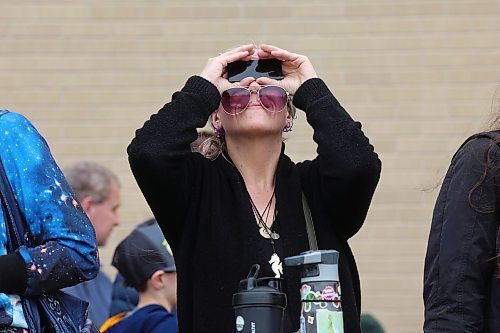 08042024
A woman peers at the solar eclipse through special glasses as the sun and passing moon poke through cloud cover over Brandon on Monday afternoon during a viewing party for the celestial event at Brandon University. 
(Tim Smith/The Brandon Sun)