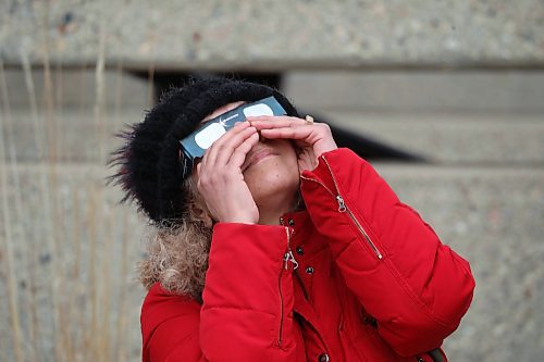 08042024
A woman peers at the solar eclipse through special glasses as the sun and passing moon poke through cloud cover over Brandon on Monday afternoon during a viewing party for the celestial event at Brandon University. 
(Tim Smith/The Brandon Sun)