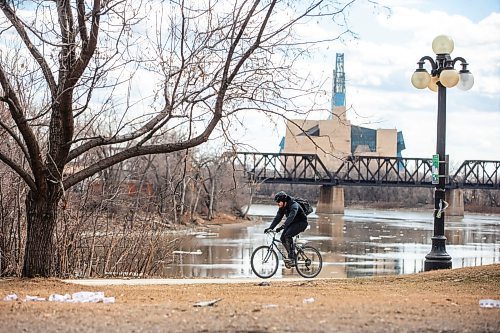 MIKAELA MACKENZIE / FREE PRESS
	
A cyclist rides past the now fully melted Red River in downtown Winnipeg on Tuesday, April 9, 2024. 

Standup.