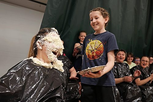 Grade 6 student Jesse Olson pies his teacher Brady Skinner during a fundraiser for Olson’s family at École Harrison on Tuesday. (Tim Smith/The Brandon Sun)