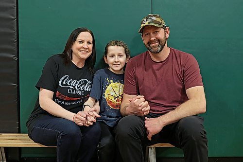 Jesse Olson with his parents Amy and Eric during a fundraiser for the family at École Harrison on Tuesday. (Tim Smith/The Brandon Sun)