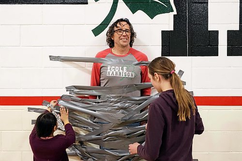 09042024
Students at &#xc9;cole Harrison duct-tape vice principal Shawn Lehman to the gymnasium wall during an assembly fundraiser for the family of eleven-year-old grade-six student Jesse Olson on Tuesday. After a battle with cancer, Olson is now cancer-free and the school sold strips of duck-tape to stick Lehman to the wall as a way of raising funds for Olson&#x2019;s family. Students also donated for the chance to be picked to pie staff members with whip-cream pies during the assembly. 
(Tim Smith/The Brandon Sun)
