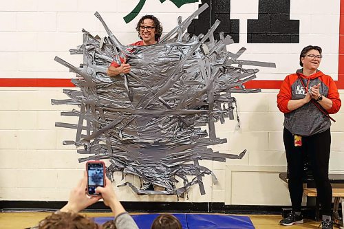 09042024
Students at &#xc9;cole Harrison celebrate after duct-taping vice principal Shawn Lehman to the gymnasium wall during an assembly fundraiser for the family of eleven-year-old grade-six student Jesse Olson on Tuesday. After a battle with cancer, Olson is now cancer-free and the school sold strips of duck-tape to stick Lehman to the wall as a way of raising funds for Olson&#x2019;s family. Students also donated for the chance to be picked to pie staff members with whip-cream pies during the assembly. 
(Tim Smith/The Brandon Sun)