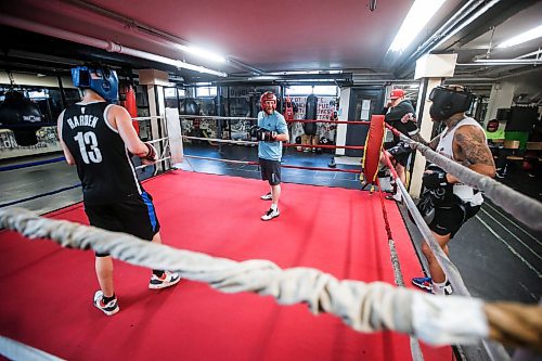 JOHN WOODS / FREE PRESS
Michael McMillan, centre, listens to some ringside coaching from Chris Sarifa, co-manager, right, as he spars with Brendan Hobson at Pan Am Place, a half-way house for men, Tuesday, April 8, 2024. 

Reporter: conrad