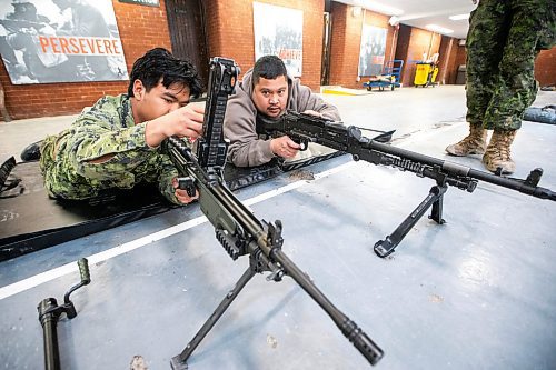 MIKAELA MACKENZIE / FREE PRESS
	
Corporal Van Mang (left) demonstrates infanteer weaponry (C6 and C9 machine guns) to Mark Requinta during an open house, which is hoping to aid army recruitment efforts, at Minto Armouries on Thursday, April 11, 2024.

Standup.