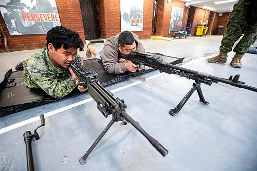 MIKAELA MACKENZIE / FREE PRESS
	
Corporal Van Mang (left) demonstrates infanteer weaponry (C6 and C9 machine guns) to Mark Requinta during an open house, which is hoping to aid army recruitment efforts, at Minto Armouries on Thursday, April 11, 2024.

Standup.