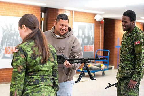 MIKAELA MACKENZIE / FREE PRESS
	
Rifleman Nyore Okene (right) demonstrates infanteer weaponry (C6 and C9 machine guns) to Mark Requinta during an open house, which is hoping to aid army recruitment efforts, at Minto Armouries on Thursday, April 11, 2024.

Standup.