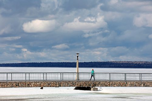 11042024
A woman walks along the pier over a still ice-covered Clear Lake in Riding Mountain National Park on a mild Thursday. 
(Tim Smith/The Brandon Sun)