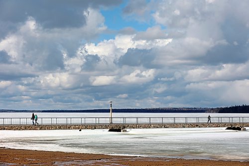 11042024
People walk along the pier over a still ice-covered Clear Lake in Riding Mountain National Park on a mild Thursday. 
(Tim Smith/The Brandon Sun)