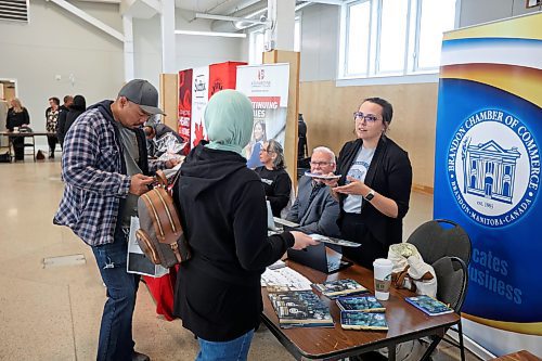 17042024
Jessica Saler, member relations and communications manager with the Brandon Chamber of Commerce, speaks with a visitor to a seminar hosted by Community Futures Westman at the Dome Building for newcomers to Canada looking to start businesses. 
(Tim Smith/The Brandon Sun)