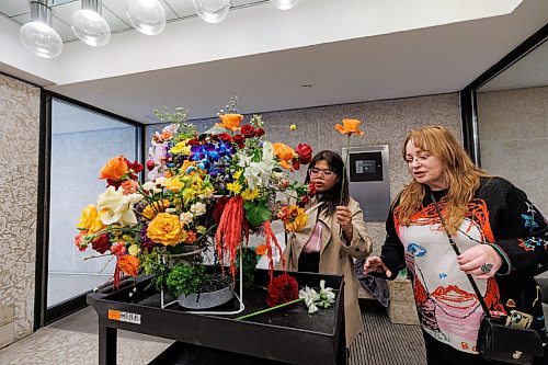 MIKE DEAL / FREE PRESS
Aira Villanueva (left) brings her arraignment into the WAG-Qaumajuq and checks it over with help from volunteer, Leonie Stranc (right).
109 professional and amateur florists will interpret 94 artworks in the WAG-Qaumajuq collection, filling the galleries with fresh flowers.
240418 - Thursday, April 18, 2024.