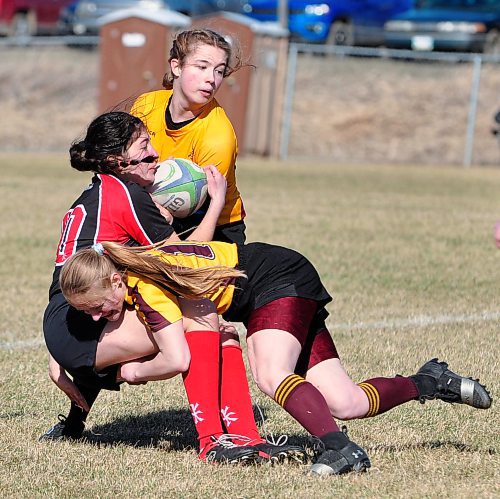 With a teammate moving in for support, Crocus veteran player Faith Burtnick tackles an advancing Swan River player during the 16th annual John Keogh Festival held Saturday at John Reilly Field, The five-team rugby festival allowed the boys' and girls' teams from Crocus, Massey, Souris, Dauphin and Swan River to prepare for the Westman High School Rugby season starting this week. See story on B1. (Jules Xavier/The Brandon Sun)