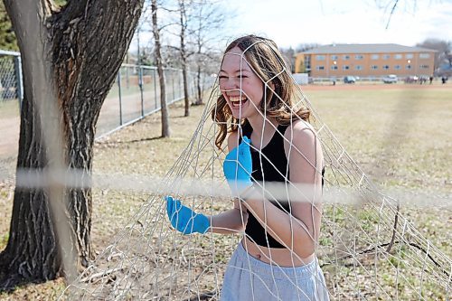 22042024
Lillian Bromley laughs after getting caught up in a soccer net while cleaning up garbage with fellow students from Vincent Massey High School on Monday in honour of Earth Day. Students in teams for all three Brandon high schools fanned out to clean up garbage in the school neighbourhoods.  
(Tim Smith/The Brandon Sun)