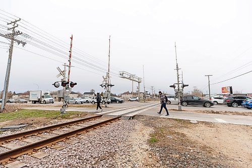 MIKE DEAL / FREE PRESS
Pedestrians walk across the rail line at Bison Drive and Pembina Highway where Winnipeg Police say a 16-year-old male sustained life-altering injuries after being struck by a train late Sunday afternoon.
240429 - Monday, April 29, 2024.