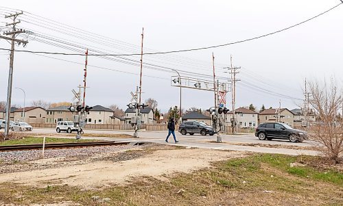 MIKE DEAL / FREE PRESS
Pedestrians walk across the rail line at Bison Drive and Pembina Highway where Winnipeg Police say a 16-year-old male sustained life-altering injuries after being struck by a train late Sunday afternoon.
240429 - Monday, April 29, 2024.