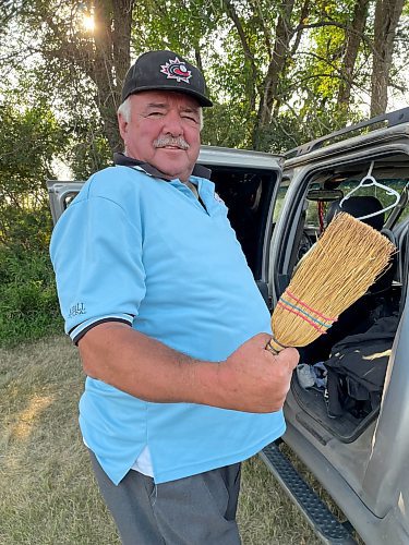 Wawanesa's Mike Fisher takes a break from farming by umpiring girls' softball and senior men's baseball, with his trusty corn broom always in his back pocket when it he needs it to sweep the plate clean. (Jules Xavier/The Brandon Sun)