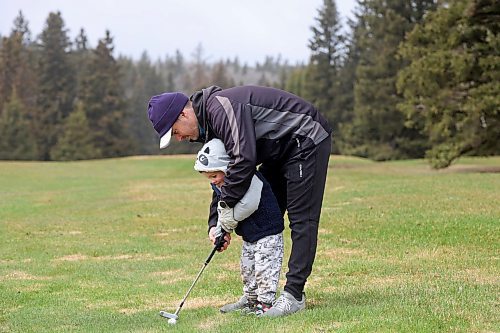 Bobby Goodman helps his three-year-old son Ledger practise his swings on a fairway during opening day at the Clear Lake Golf Course on a rainy Friday afternoon. (Tim Smith/The Brandon Sun) 