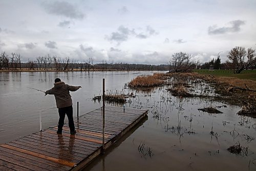 03052024
Spade Uchendu doesn&#x2019;t let the wet weather discourage him from fishing from the dock at Dinsdale Park on Friday morning. 
(Tim Smith/The Brandon Sun) 