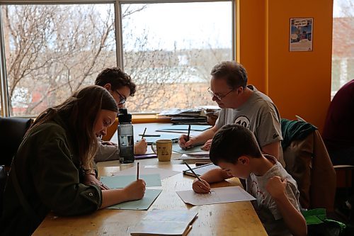 Emmitt and Clare Workman, Jeremy Carter, and Curt Shoultz work on their comics at the AGSM's Free Comic Book Day. (Charlotte McConkey/The Brandon Sun)